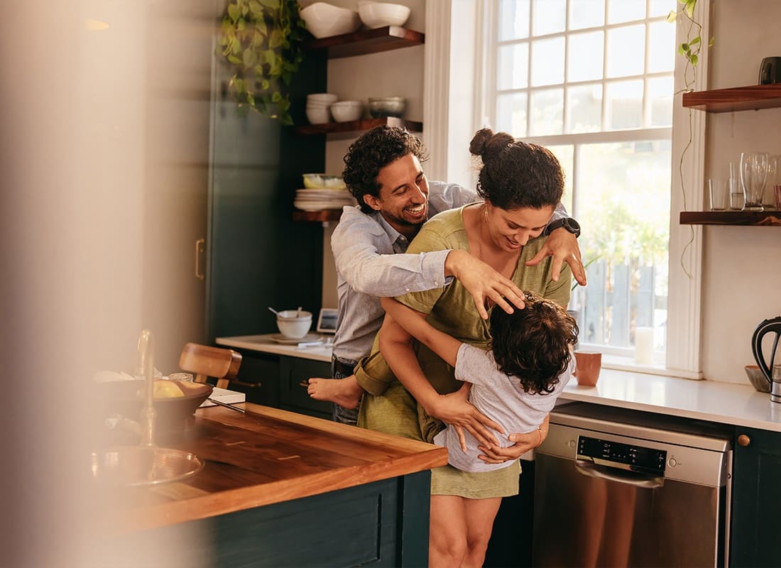 Insurance Solutions - Parents Playing With Their Son in the Kitchen