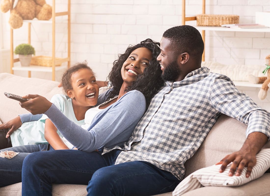 Personal Insurance - Joyful Family Having Fun Together and Relaxing on Sofa at Home
